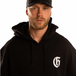 closeup of model with cap and a black great injuries hoodie